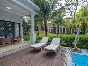 a patio with chairs and a table and a pool at Vinpearl Wonderworld Phu Quoc in Phu Quoc