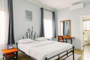 1 Schlafzimmer mit einem Bett, 2 Tischen und einem Spiegel in der Unterkunft Sarita Village Homes in Arusha