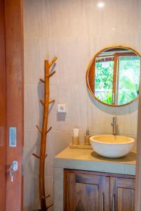 a bathroom with a sink and a mirror at Cempaka Kembar Guest House Ubud in Ubud