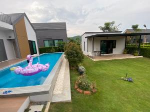a house with a swimming pool in a yard at Pool34 in Ban Bung Toei