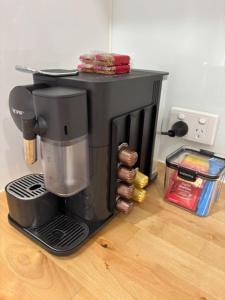 a coffee maker sitting on top of a wooden floor at Port Denison Stays - Unit 1 in Port Denison