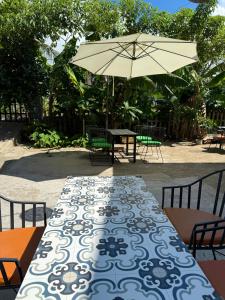a table with a blue and white table cloth and an umbrella at Eden House & Coffee Con Dao in Con Dao