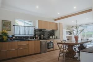 a kitchen with wooden cabinets and a table with chairs at Harker House in Healesville