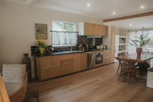 a kitchen with wooden cabinets and a table and a dining room at Harker House in Healesville +39 photos