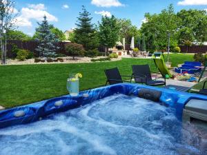 a hot tub in a backyard with chairs and a lawn at Sika President Garden & Spa Central Apartment Arad in Arad