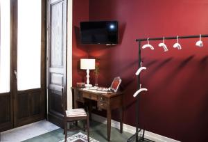 Habitación con escritorio y pared roja. en Art Fashion House Luxury Rooms, en Catania