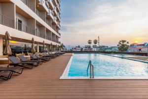 a swimming pool at a hotel with lounge chairs at Jomtien Thani Hotel in Jomtien Beach