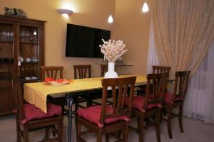a dining room table with chairs and a vase of flowers at Green Residence Sirmione in Desenzano del Garda