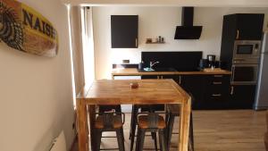 a kitchen with a wooden table and some chairs at Appart Côte d'Opale in Condette