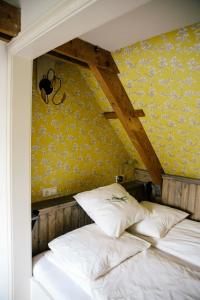 Cama en habitación con pared amarilla en Louisehoeve Holiday Home, en Linschoten