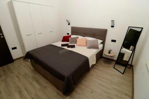 a bedroom with a large bed and a mirror at Fidelis Apartment - Walk to the Beach in Minutes in Novi Vinodolski