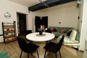 a living room with a table and a green couch at Fidelis Apartment - Walk to the Beach in Minutes in Novi Vinodolski +14 photos