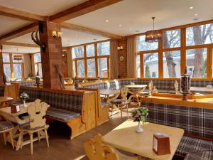 a restaurant with tables and chairs and windows at Splendor Resort and Restaurant in Tsaghkadzor