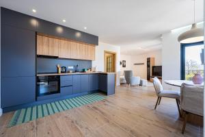 a kitchen with blue cabinets and a dining room at Barber Apartment in Tivat