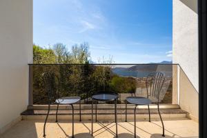 two chairs and a table on a balcony with a view at Barber Apartment in Tivat