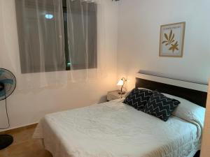 a small bedroom with a bed and a window at Apartamento María Isabel en Los Collados Golf - Aguilas in Águilas +59 photos