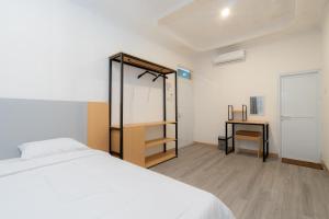 une chambre avec un lit blanc et un bureau dans l'établissement Villa Fiorenza III, à Sampal 2 22 autres photos