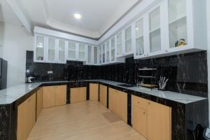 une cuisine avec des armoires blanches et des comptoirs noirs dans l'établissement Villa Fiorenza III, à Sampal 2