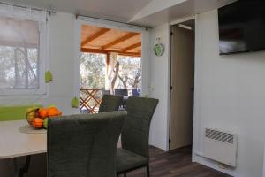 a dining room with a table and chairs at Mobile Home Olive Tree in Pakoštane