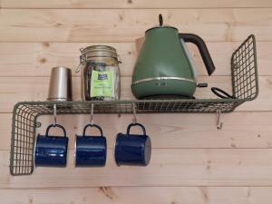 a wire shelf with a tea pot and tea tags at Le Cabanon du camping in Bannes