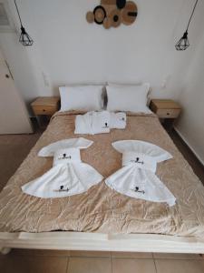 łóżko z białymi ręcznikami i poduszkami w obiekcie ARTEMIS beach studios w mieście Kalamaki