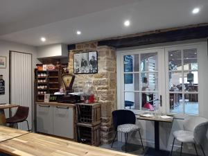 a kitchen with a table and chairs and a stone wall at Au bord de l'eau Salles sur Cerou in Salles