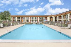 a large swimming pool in front of a building at Days Inn by Wyndham Ruther Glen Kings Dominion Area in Ruther Glen