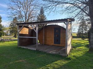 a wooden dog house with a door in the grass at Le Cabanon du camping in Bannes