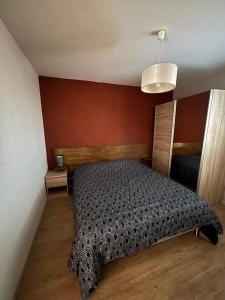 ein Schlafzimmer mit einem Bett und einer roten Wand in der Unterkunft Appartement de Romain in Annecy