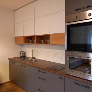 a kitchen with a sink and a microwave at Prameň pokoja in Trnava