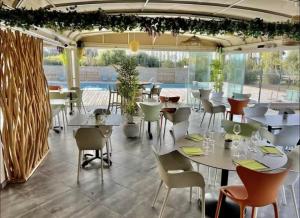 a restaurant with tables and chairs and a pool at Cala Serena Saint Cyprien in Lecci