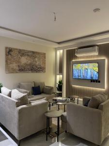 a living room with couches and a flat screen tv at منزال in Al Madinah