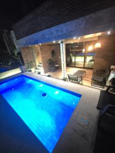a swimming pool at night with blue lights at LOFT COSTANERA 200mts in Encarnación