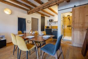 a dining room with a wooden table and chairs at Le perchoir du Saint-Didier in Avignon