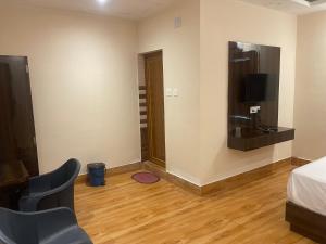 um quarto com uma cama e uma televisão na parede em Shree Premium Hotels & Kamala Resort em Bhubaneshwar