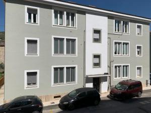 un edificio bianco con due auto parcheggiate di fronte di Aussiehome ad Ascoli Piceno
