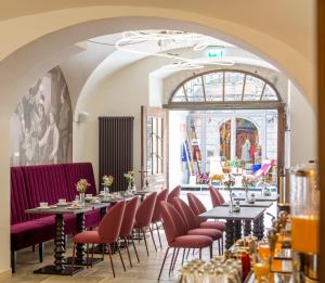 a restaurant with tables and chairs and a large window at Altstadthotel der Patrizier in Regensburg