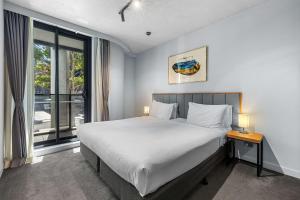 メルボルンにあるClarion Apartments South Melbourneのベッドルーム1室(ベッド1台、大きな窓付)