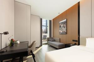 une chambre d'hôtel avec un lit et un bureau dans l'établissement Atour Hotel Guangzhou Panyu Nancun Wanbo Subway Station, à Canton 61 autres photos