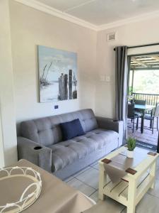 een woonkamer met een bank en een tafel bij Banana Beach B4 in Melville