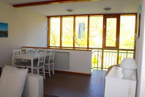 ein Wohnzimmer mit Tisch und Stühlen und Fenstern in der Unterkunft Ferienwohnung Altes Pfarrhaus mit Flair und Moselblick in Brauneberg + 23 Fotos