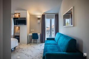 a living room with a blue couch and a bedroom at Hotel Villa Elena in Varazze