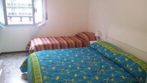 1 dormitorio con 1 cama con manta azul y flores amarillas en Edolo Apartment en Milán