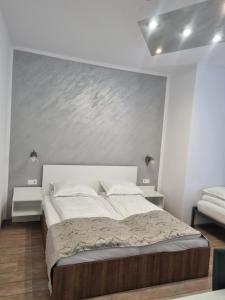 a bedroom with a large bed with a painting on the wall at Unilux Residence in Beiuş