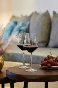 twee glazen wijn op een tafel met druiven bij Cozy Apartment View Pasalimani in Piraeus