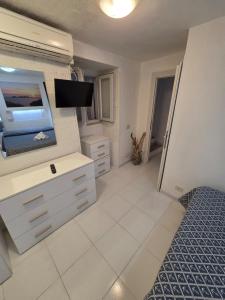 a living room with a television and a bedroom at Agenzia Aprea Appartamenti in Ponza