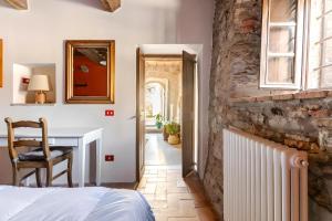 una camera da letto con un letto, una scrivania e uno specchio di Sambuca Lodge a San Romano