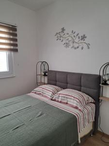 a bedroom with a bed with a blanket on it at Robinzon kuća Niko in Zadar