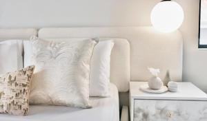 Sofá blanco con almohada y mesa auxiliar en Green Paradise Luxury Apartment Modderfontein, en Sandton