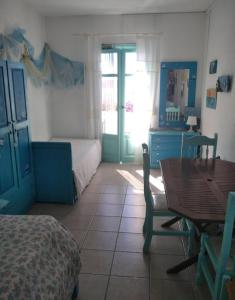 a room with a bedroom with a table and a bed at Λιογερμα in Koufonisia